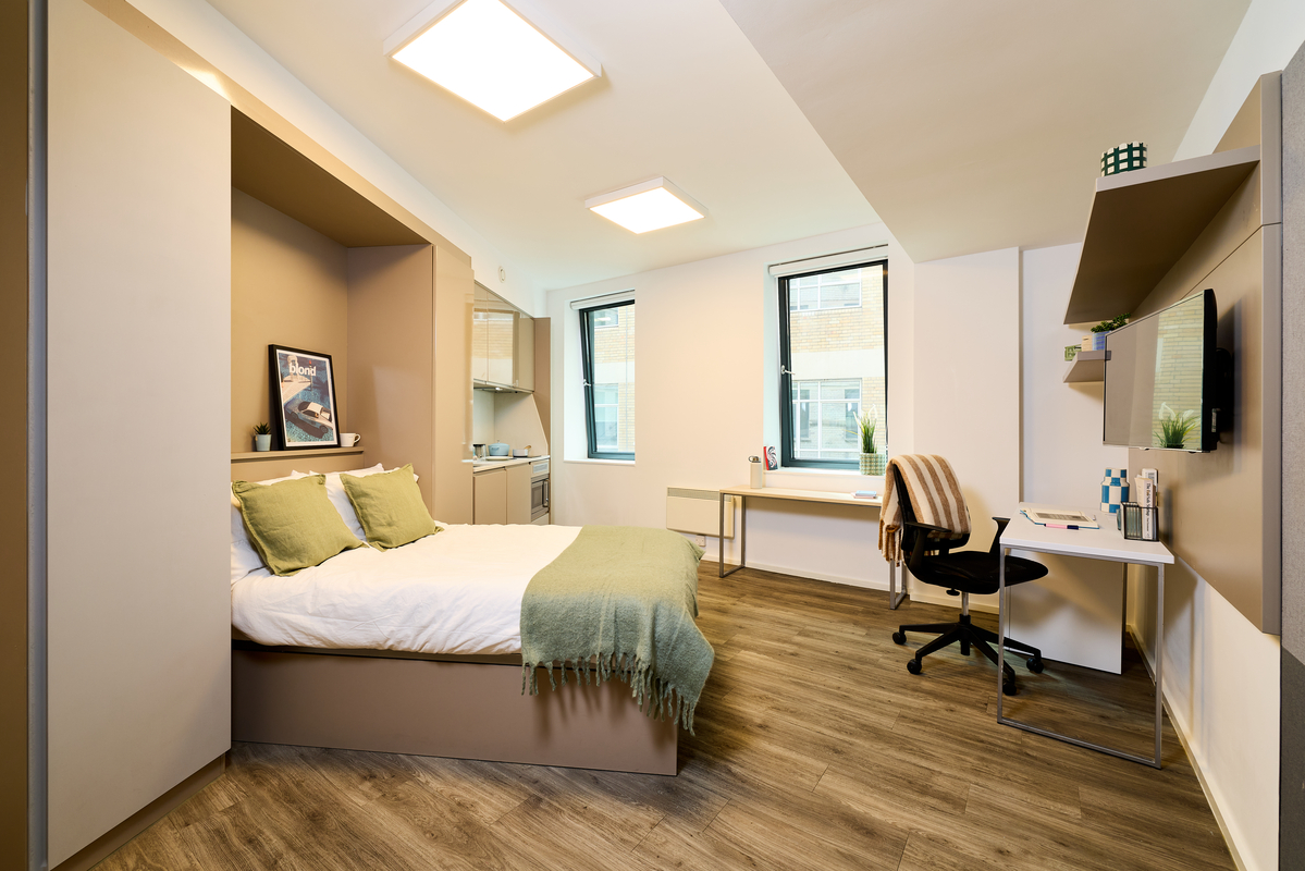 A bedroom with a desk and a bed.