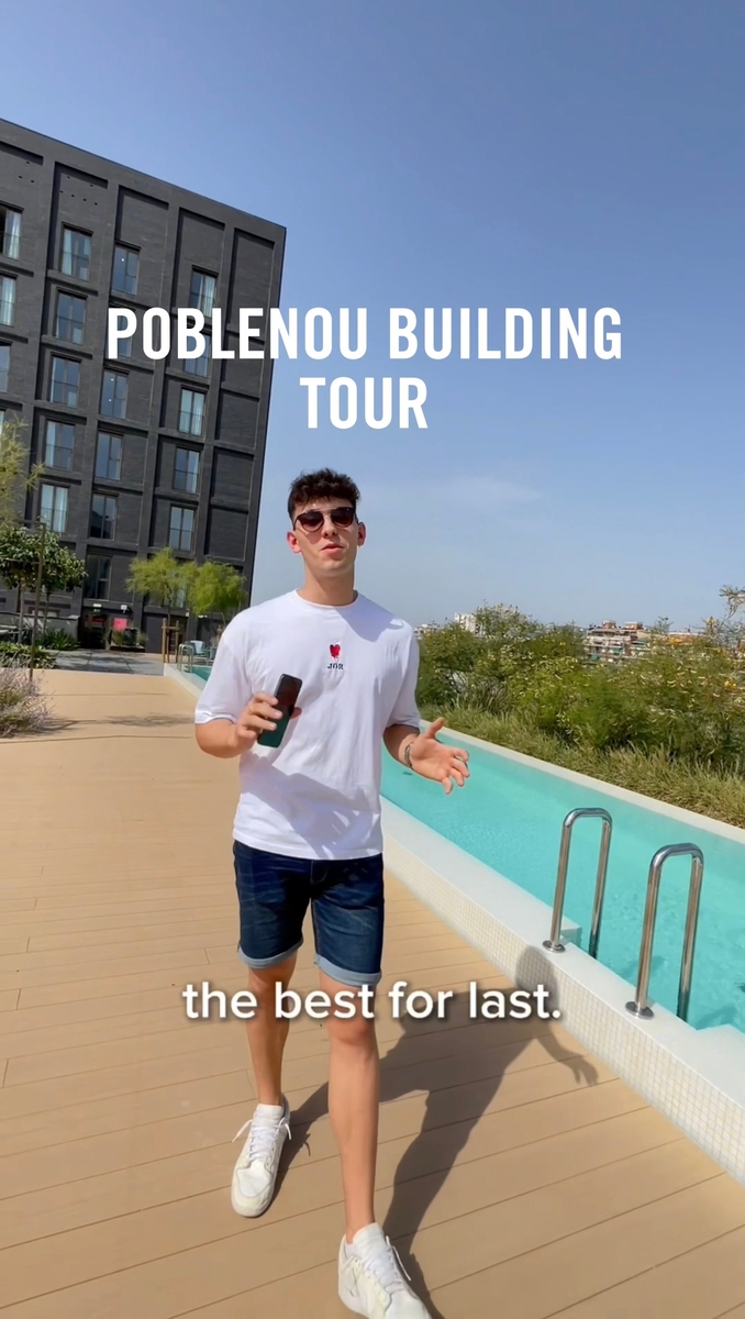 Young man in sunglasses and a white t-shirt, holding a phone and walking on a boardwalk by a pool. Background shows a modern building and plants under a clear blue sky. Text reads "Poblenou Building Tour" and "the best for last.