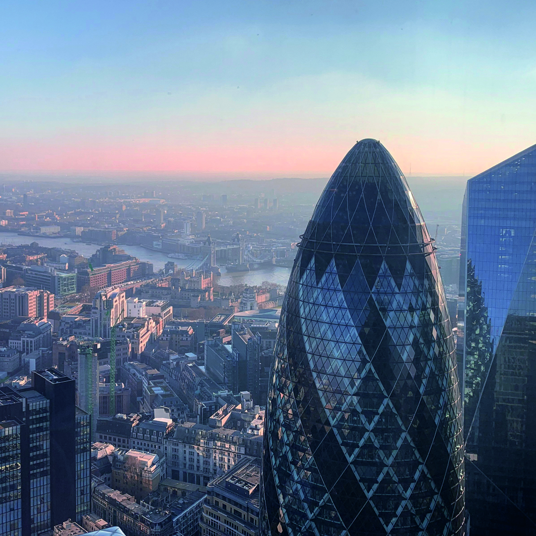 Aerial view of London at sunset featuring the Gherkin skyscraper, with the River Thames and Tower Bridge in the background—a stunning cityscape for those seeking the best student accommodation in London.