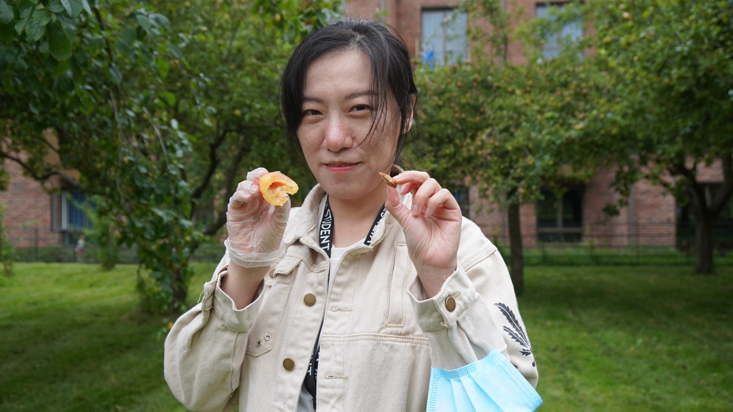 A woman is eating a piece of fruit.
