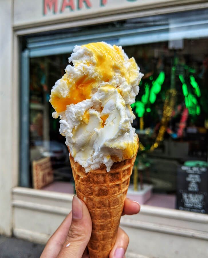 A ice-cream cone with gelato and sauce. 