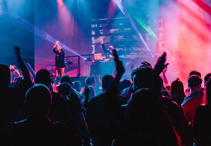 A crowd facing a DJ set.