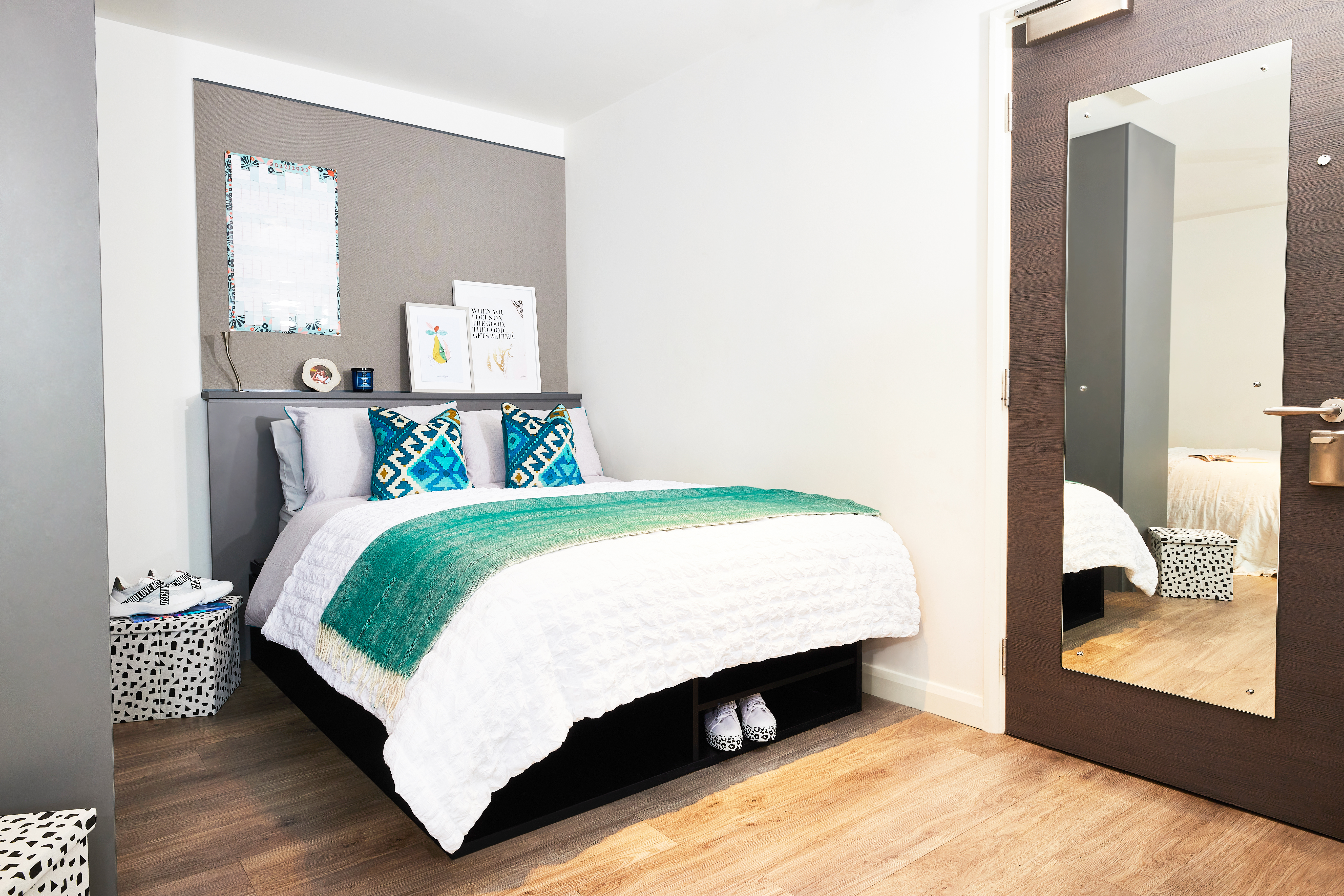 A bed with a circular mirror and a square door.