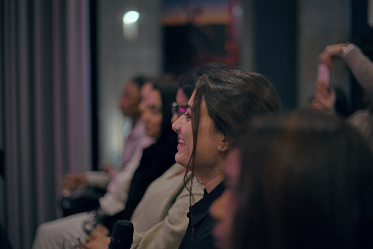 Girls face sat in crowd watching guest speakers during International Women's Day