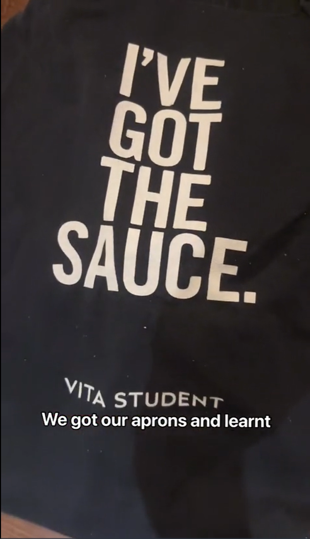 A dark apron with the words "I've got the sauce" printed in bold white letters. Below, the logo "Vita Student" is visible. The text "We got our aprons and learnt" is overlaid at the bottom of the image.