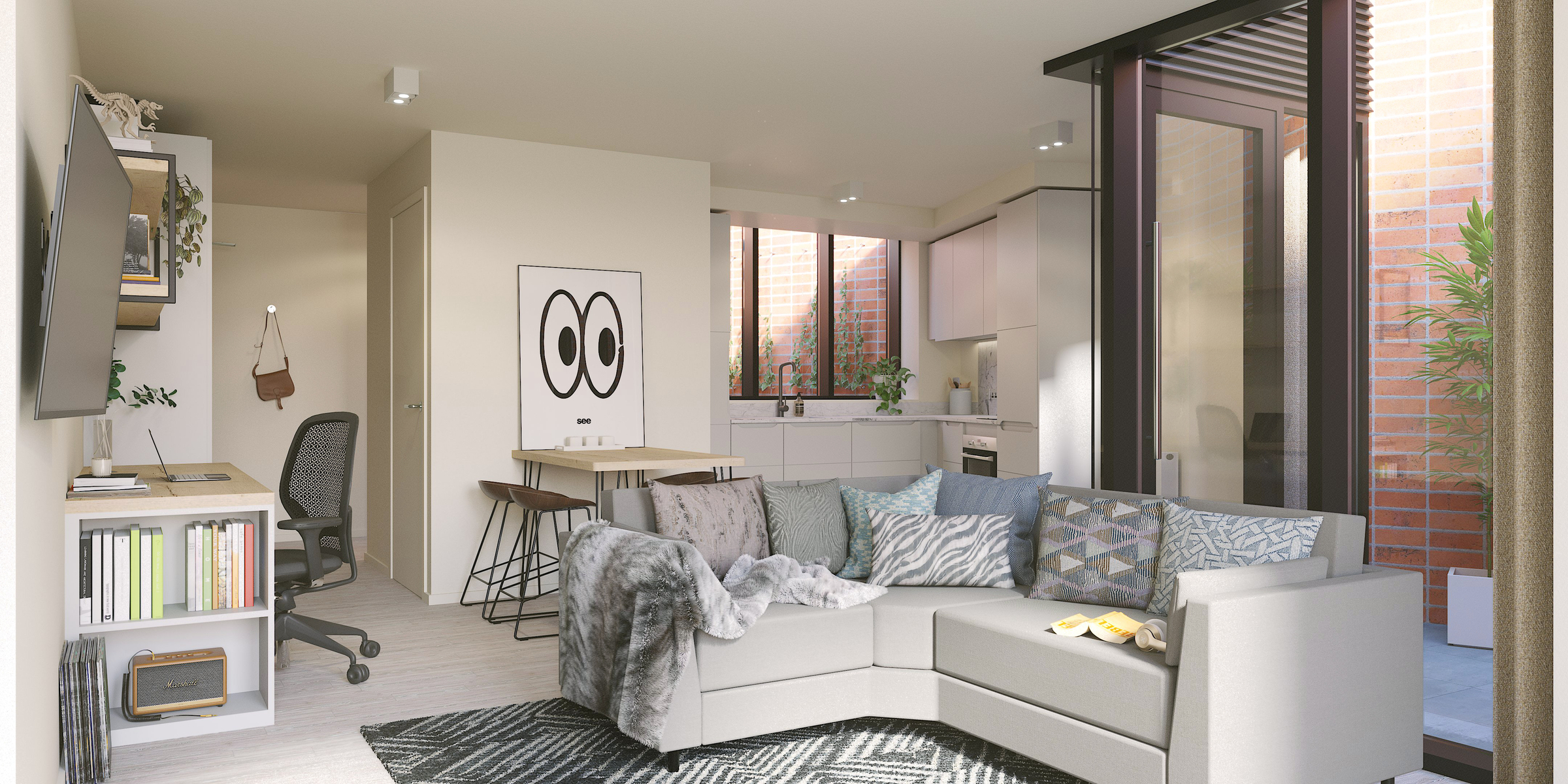 A modern, bright Gough Street living room features a gray sectional sofa, many cushions, a desk with a chair, wall-mounted TV, and kitchen area. Large windows open to a patio with brick walls and potted plants.