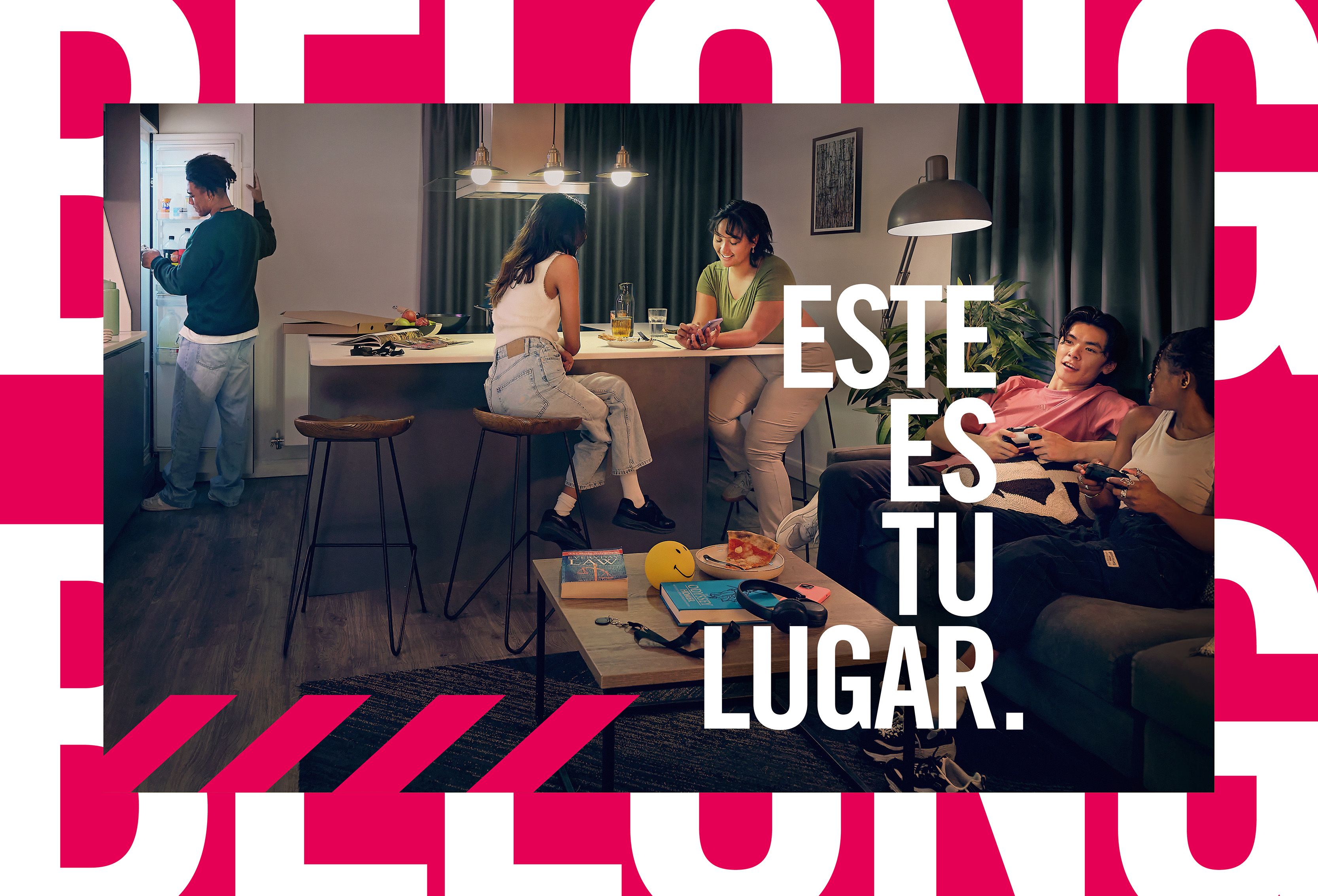 Six young adults relax in a cozy living room, chatting, eating, and playing video games. Bold white Spanish text reads “ESTE ES TU LUGAR,” meaning “THIS IS YOUR PLACE,” over a pink graphic border.
