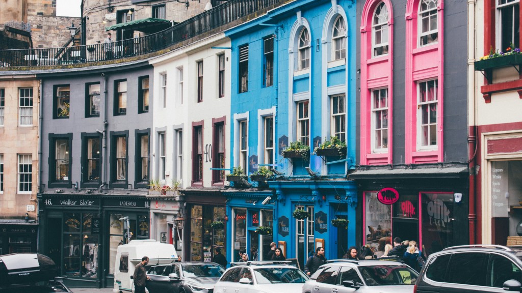 A vibrant street scene near New Waverley, with colorful buildings, shops, parked cars, and people strolling—perfect for students seeking things to do near New Waverley or fun student activities in the area.
