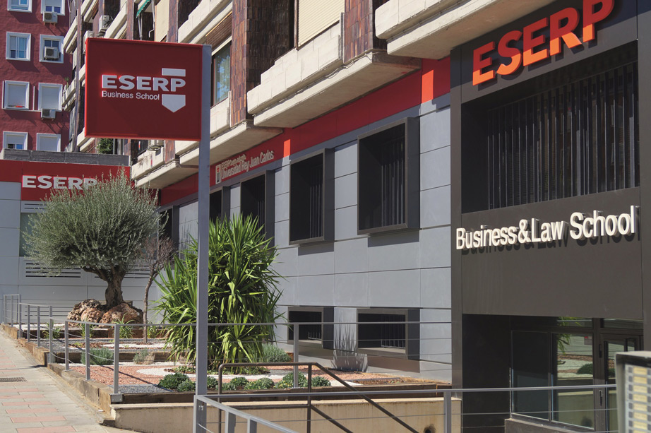 Modern building with signs reading "ESERP Business School" and "Business & Law School" on the facade. The exterior features landscaped plants, a sidewalk, and nearby options for student accommodation in Madrid.