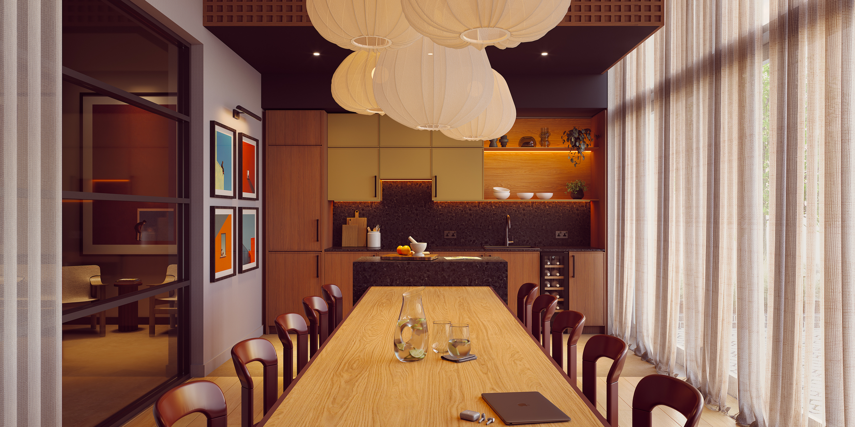 A modern kitchen on India Street features wooden cabinets, a long dining table surrounded by brown chairs, pendant lights, large windows with sheer curtains, and contemporary art on the wall. A glass pitcher, cups, and a notebook are thoughtfully arranged on the table.