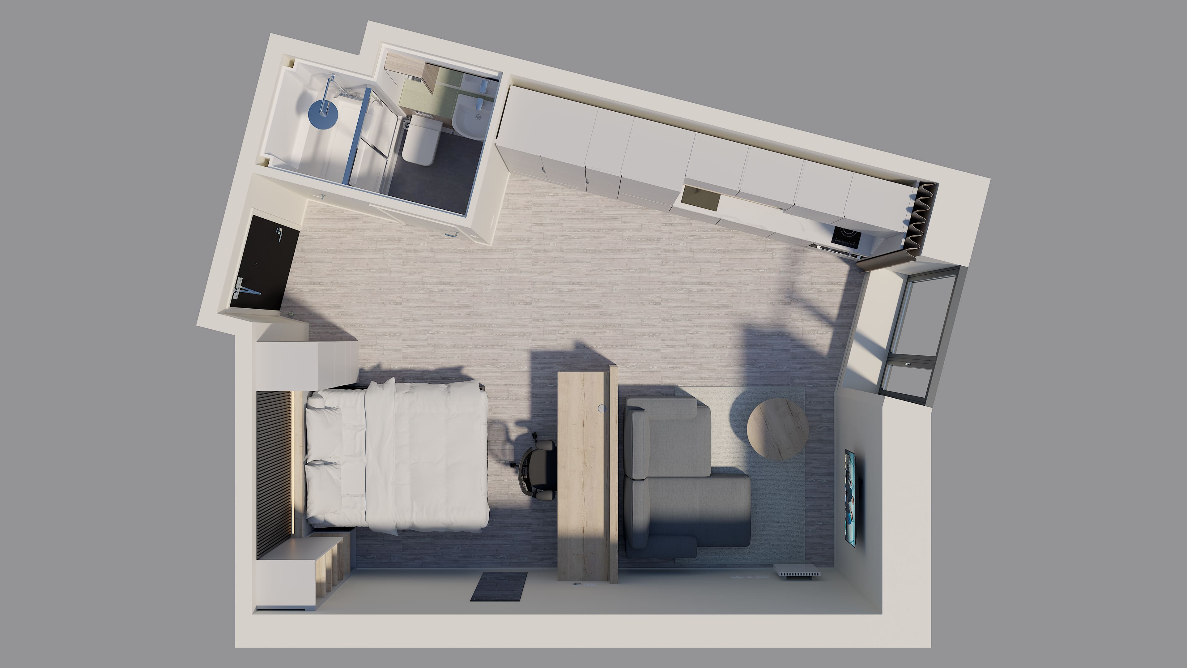 Top-down floor plan of a studio apartment showing a bedroom area, kitchen, bathroom, and living space with a desk and sofa.