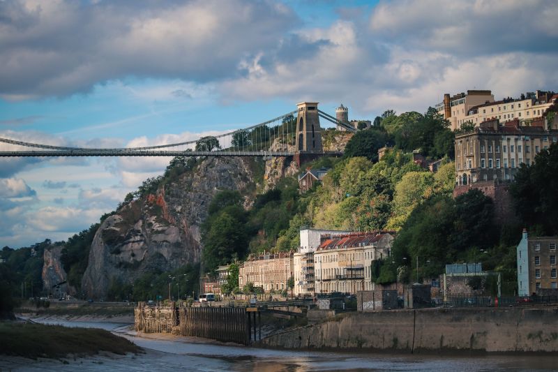 Clifton Suspension Bridge spanning the Avon Gorge above rows of buildings on the riverbank in Bristol, a popular destination for student travel from Birmingham.