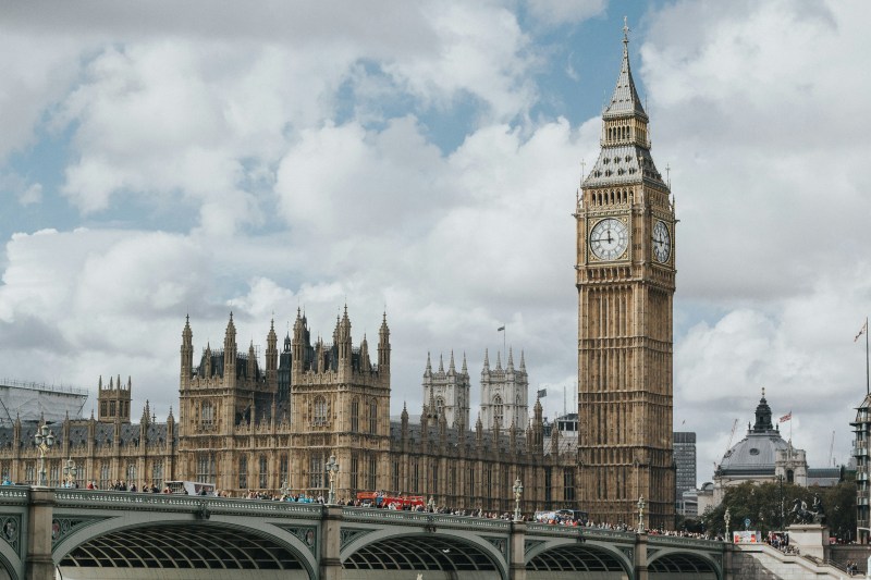 The Elizabeth Tower, housing Big Ben, and the Palace of Westminster viewed from across the bridge under a cloudy sky, a popular destination for student day trips.